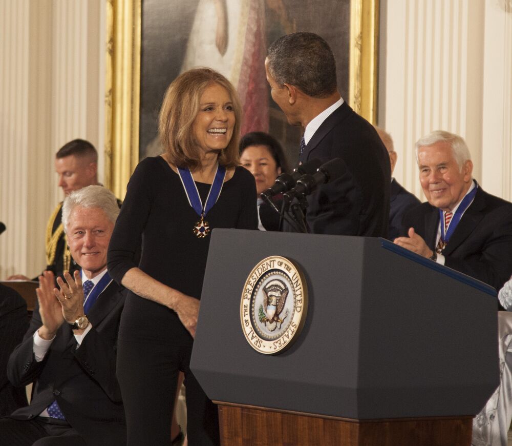 Gloria Steinem, wearing all black, recieves the Presidential Medal of Freedom from Barak Obama.