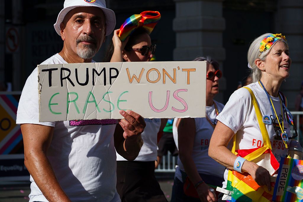 Osoba drží a "Trump nás nevymaže" znamenie